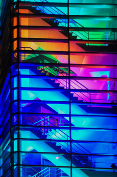 abstract background of staircase and glass in building at night in vibrant neon lights