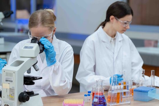 Two Asian female scientists talk Discuss concepts and use PC in evaluating research data in Medical research center laboratory medical science concept.