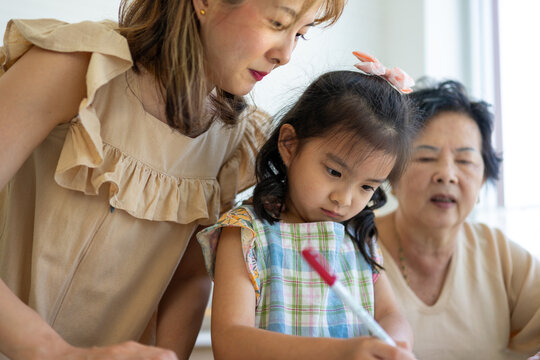 Three generations bond over writing near a window
