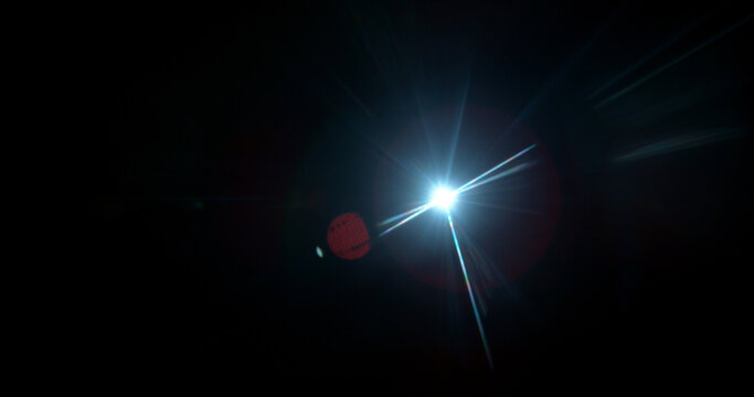 Intense cinematic light flare radiating from a bright source on dark background. Realistic optical effect ideal for film production, visual effects and dramatic compositions.