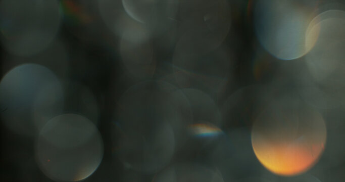 Abstract cinematic lens flare with soft bokeh circles and subtle light reflections. Atmospheric optical effect background ideal for overlays, visual effects, film production and creative design.