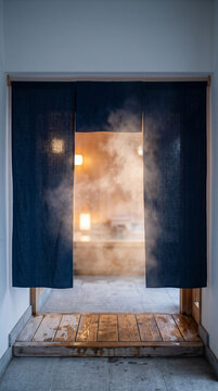 Steam drifting through a plain indigo noren curtain Japanese onsen entrance, close-up with copy space at top