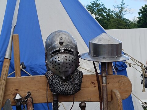 Medieval Knight Helmets and Weapons Displayed at Historical Reenactment Camp