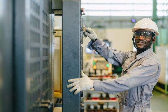 Portrait Happy Smiling Black Engineer Operating CNC Machine in Metal Part Industry Factory