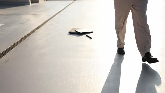 Employee works on laptop while walking then smashes the computer on ground after a serious work failure showing anger frustration and stress from unsuccessful work failures