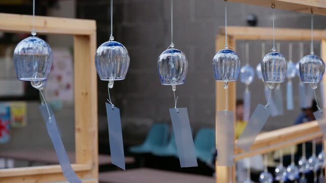 Close-Up Shot of Clear Blue Glass Wind Chimes Hanging on Wooden Frames