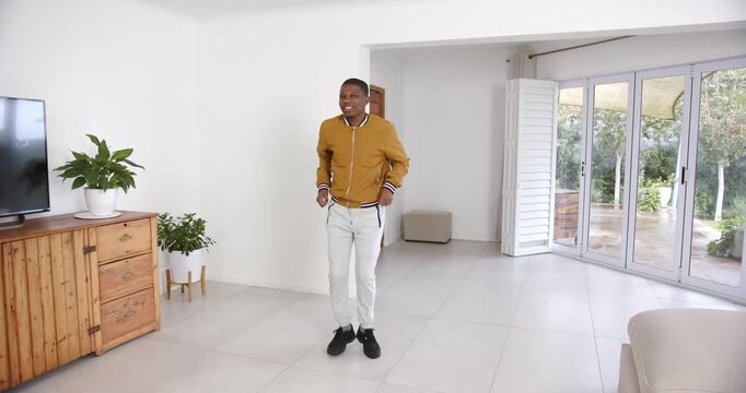 High speed photography for dynamic scenes, smiling man standing in modern living room with wooden fu