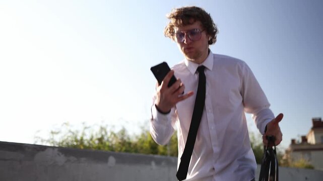 Student walks to an important exam checking his phone while carrying a briefcase and feeling focused nervous and under pressure before a challenging university test today