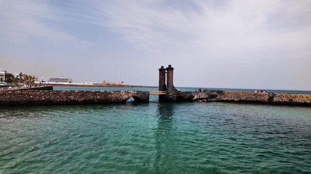 Slow motion view of Puente de las Bolas bridge and stone turrets, Arrecife, Lanzarote