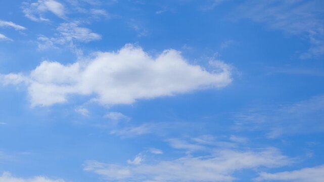 A blue sky cloud timelapse video captures scattered cumulus clouds and thin cirrus formations drifting in gentle winds, creating a bright blue atmosphere with sunny, fair weather. 4k.
