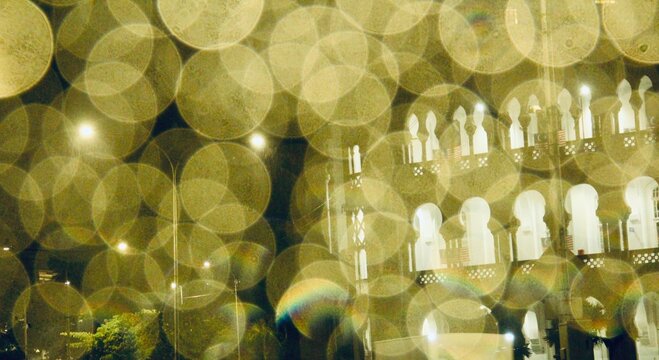 Beautiful abstract out-of-focus background of urban night lights. Golden circles of light and vintage architectural outlines create a dreamy, romantic, and cinematic atmosphere, perfect for design tex