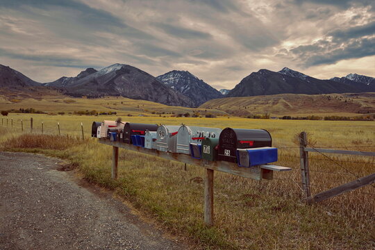 Bunch of mailboxes at the State Hwy.540 and the Deep Creek Rd.junction, backed by the Absaroka Range peaks under a cloudy sky. Livingston-MT-USA-001