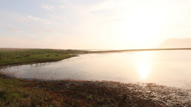 pale sunset over lagoon and reflection of klein mountains, stanford, south africa