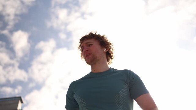 Young runner blows his nose during outdoor training after feeling discomfort while exercising showing a common interruption during cardio workout and active sport routine