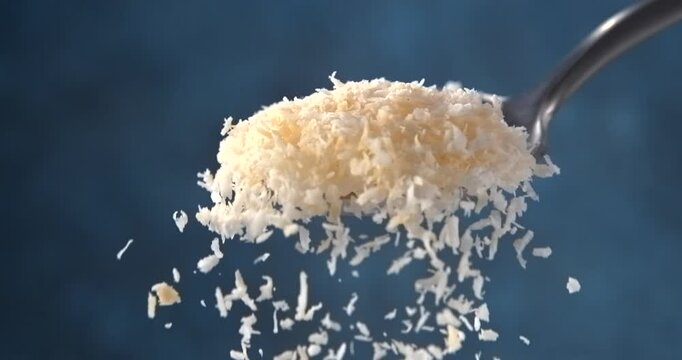 Coconut flakes falling from a spoon in slow motion