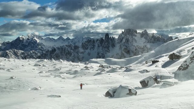 Beautiful Winter Dolomite Mountain Scenery with Man on Cross-Country Skis , Aerial View