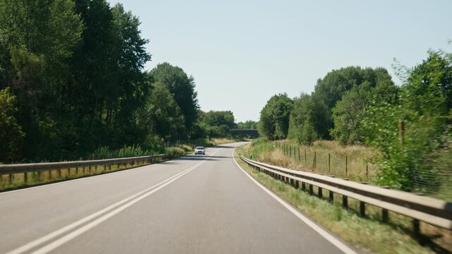 View of the road through the car's windshield an oncoming car and a truck