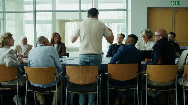 Business professionals from diverse backgrounds actively participate in a lively conference meeting. They are collaborating, sharing ideas, and engaging in discussions around a table.