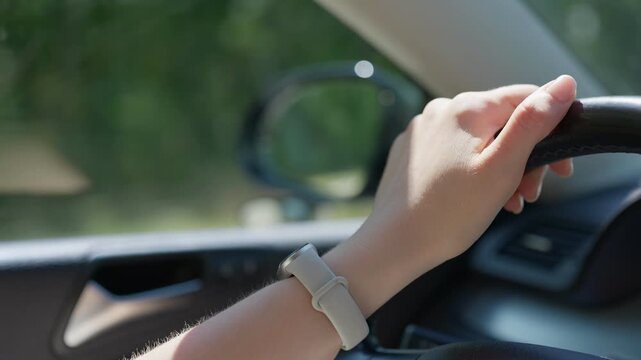 Driver hand on steering wheel in car slow motion close up transition pulling focus to the side mirror