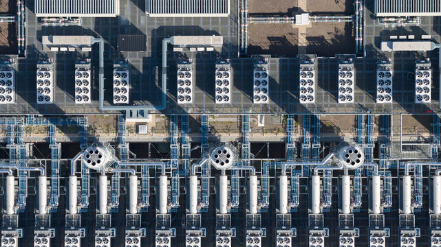 Aerial view of the industrial rooftop featuring rows of HVAC cooling units, complex ventilation pipes, and technical infrastructure in Dietzenbach, Hessen, Germany.