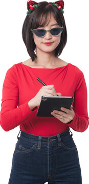 Happy young asian woman wearing sunglasses and headband holding tablet computer preparing shopping list for big christmas sale and black friday promotion on transparency background