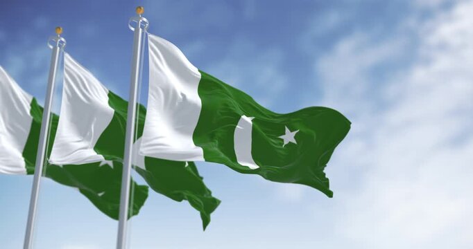 Pakistan National flags waving on a clear day. Green with white band on hoist; white crescent moon and five-pointed star. 3d illustration render. Selective focus
