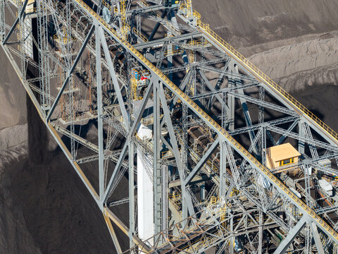 Aerial view of the Tagebau Welzow-Sud brown coal open-pit mine featuring a massive steel conveyor bridge and industrial extraction machinery in Spremberg, Brandenburg, Germany.