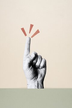 Cutout hand pointing index finger up with exclamation marks on beige background