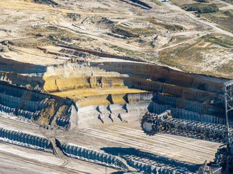 Aerial view of Tagebau Welzow-Sud brown coal open-pit mine showing deep excavation layers, industrial machinery, and vast earthworks, Spremberg, Brandenburg, Germany.