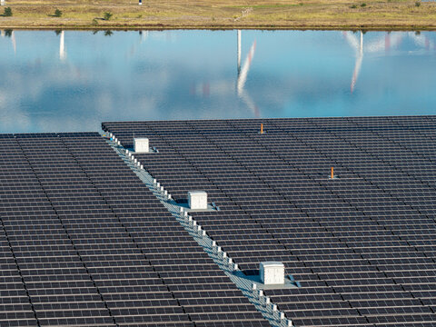 Aerial view of the floating solar farm at Cottbuser Ostsee, showing rows of solar panels and maintenance walkways on the water surface in Cottbus, Brandenburg, Germany.