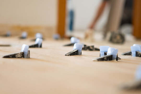 Tile leveling system wedges securing flooring installation