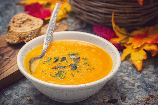 Homemade pumpkin soup served with parsley and pumpkin seeds