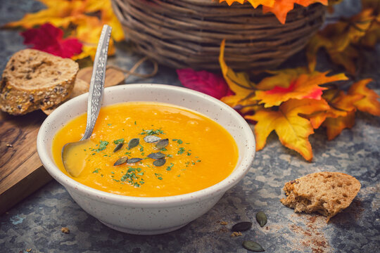 Homemade pumpkin soup served with parsley and pumpkin seeds