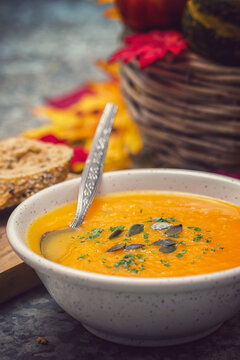 Homemade pumpkin soup served with parsley and pumpkin seeds