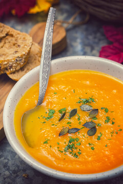 Homemade pumpkin soup served with parsley and pumpkin seeds
