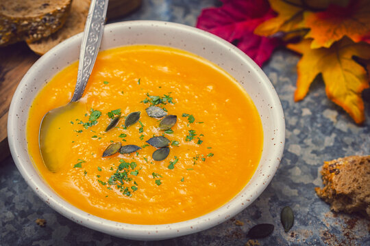 Homemade pumpkin soup served with parsley and pumpkin seeds
