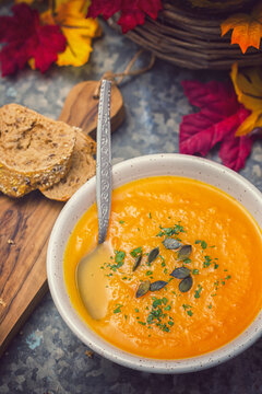 Homemade pumpkin soup served with parsley and pumpkin seeds