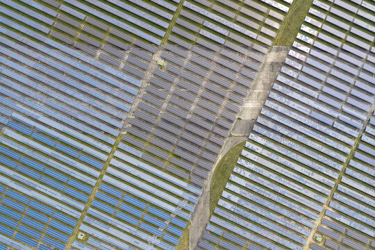 Aerial view of the solar field at the former military airfield in Preschen, with rows of solar panels across the historic runway and taxiway in Neisse-Malxetal, Brandenburg, Germany.