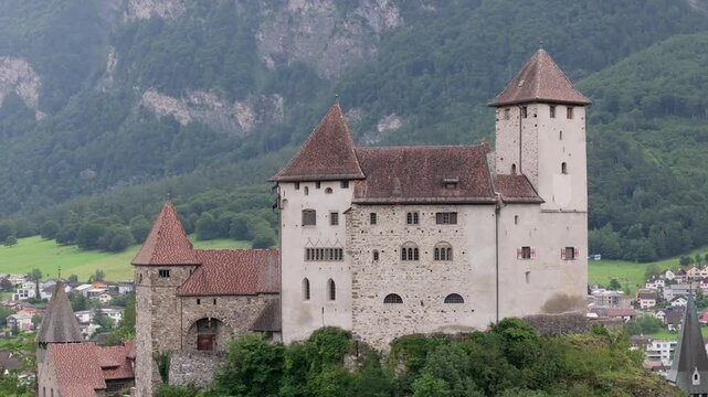 Aerial view of Vaduz Castle perched on a hill overlooking the town with lush green mountains in the background, Liechtenstein.