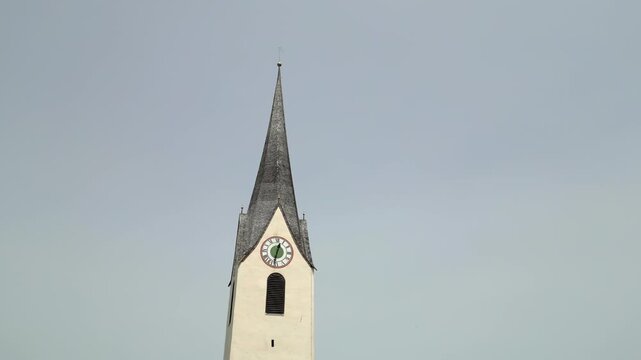 Aerial view of church steeple with clock face against clear sky Liechtenstein.