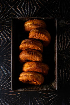 Donuts in a metal baking loaf pan on a dark surface 