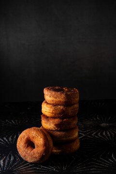 Stack of cinnamon donuts on a dark surface 