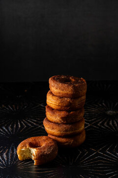 Stack of cinnamon donuts on a dark surface 