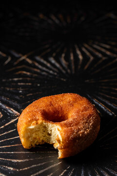 Donut with a bite on a dark surface 