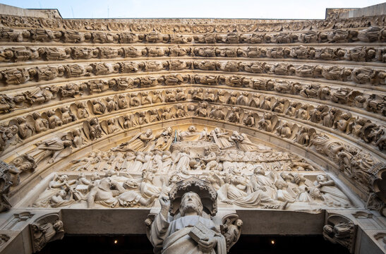 Detail of carved stone tympanum and voussoirs above the central portal, Notre-Dame Cathedral, Paris, France
