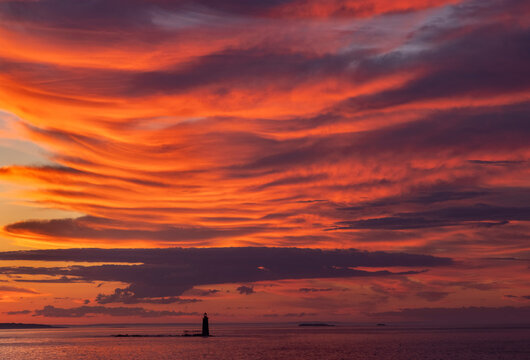 Spectacular sunrise clouds over Ram Island Ledge Lighthouse in Portland, Maine, USA
