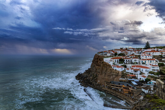 Tiny village of Azenhas do Mar with sunset clouds near Colares, Portugal
