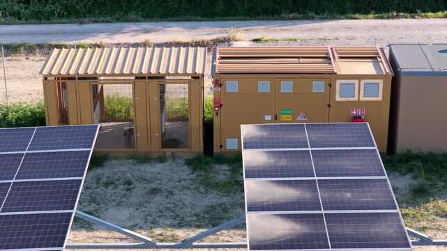 Aerial view of solar panels and a utility enclosure in a rural area in Faenza, Emilia-Romagna, Italy.
