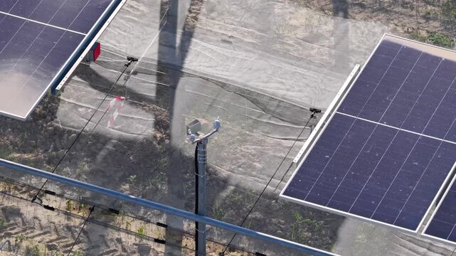 Aerial view of solar panels installed in a field with a sensor pole in Faenza, Emilia-Romagna, Italy.