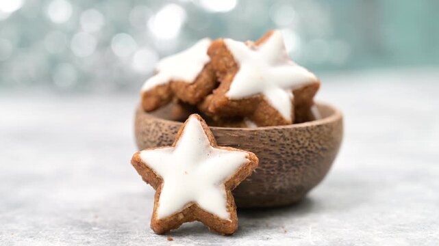 Christmas holiday sweets, homemade cinnamon stars with hazelnuts and almonds, cookies and biscuits with icing glaze, bokeh light